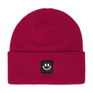 Close-up of deep magenta cuffed knit beanie with square black smile face patch logo