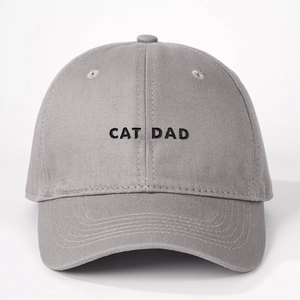 Close-up of black CAT DAD embroidery on a medium grey cotton twill baseball cap fabric