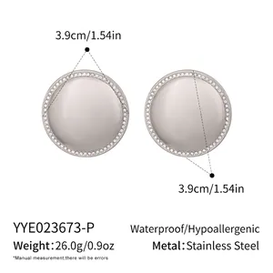 Macro detail of 3.9cm domed stainless steel earrings with sparkling white stone inlay