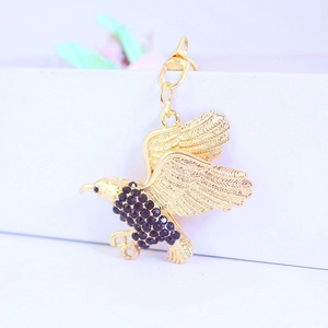 Detailansicht eines goldenen Adler-Schlüsselanhängers mit glitzernden Strasssteinen