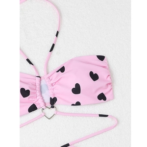 Détail du haut de bikini rose à motifs cœurs avec un anneau métallique argenté
