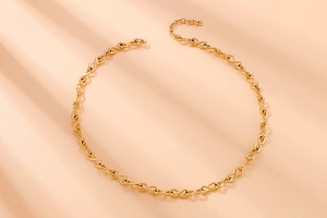 Dettaglio macro della collana in acciaio inossidabile dorato con maglie a forma di otto infinito