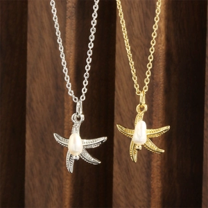 Detail of 18K gold and silver starfish pendants with elegant pearls on fine chains