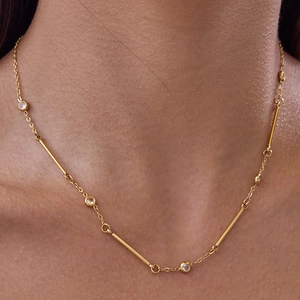 Collier minimaliste en acier doré 18K avec zircon rond et détails de tubes dorés
