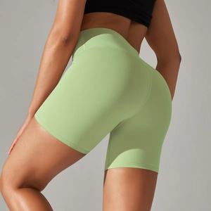 Detail of high-waisted seamless green yoga shorts with butt-lifting fit on model