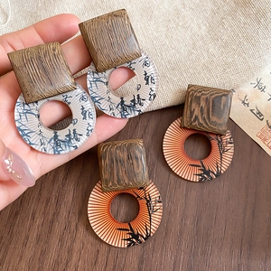 Detailed view of vintage ethnic wooden earrings with resin patterns and calligraphy motifs