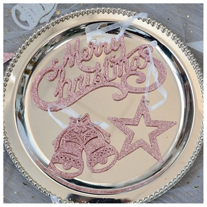 Detail of rose gold Christmas ornaments with glitter including star, bells and Merry Christmas sign