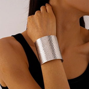 Detail of silver metallic textured wide cuff bracelet with a hammered surface on wrist