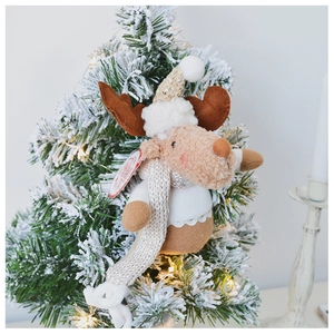 Plush Christmas reindeer ornament with sequins hanging on a snowy tree branch
