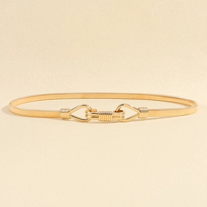Close-up of golden elastic metal waist chain with elegant interlocking geometric buckle
