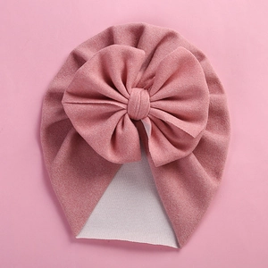 Pink cashmere-like baby turban hat with a large 3D bow and soft knitted texture