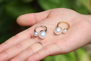 Minimalist adjustable open pearl ring in gold and silver finish shown on palm
