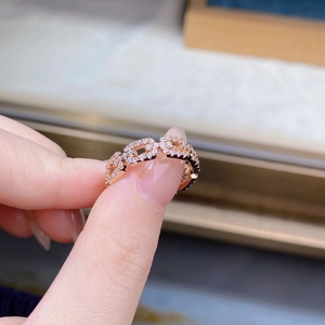 Detailed view of rose gold pig nose ring with pave-set zircon stones on finger