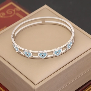 Silberner Armreif mit blauem Emaille-Herz und Kristallen auf einer Geschenkbox