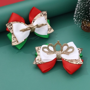 Detail of Christmas bow hair clips with gold reindeer antlers and crown ornaments