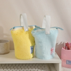 Cute plush pencil case with handle and zipper standing on desk in yellow and blue
