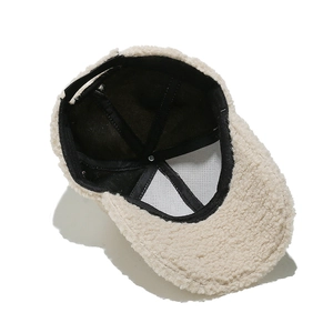 Detail view of the interior lining and stitching of the beige sherpa baseball cap