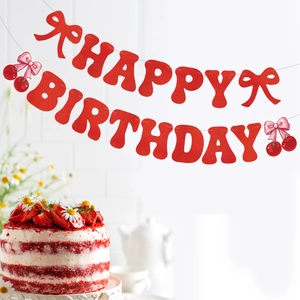 Close-up of glittery Happy Birthday banner with cherry and pink bow party decorations