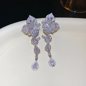 Macro shot of silver tassel earrings with zircon leaves and a water drop crystal pendant