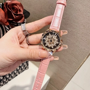 Detail of pink leather watch with rotating snowflake diamond dial and gold case