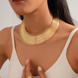Close-up of a layered gold metal choker necklace with a sleek geometric stacked design