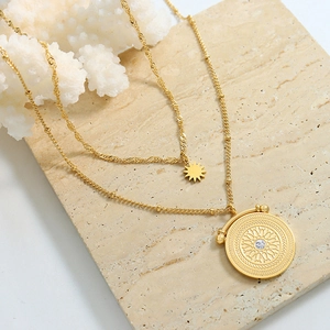 Double-layered gold titanium steel necklace featuring starburst and circular stone pendants
