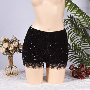 Détail du short noir à paillettes avec bordure en dentelle délicate et texture brillante