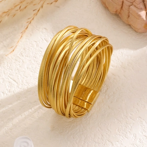 Detailed view of multilayer gold metal wire bracelet with a wide magnetic buckle closure