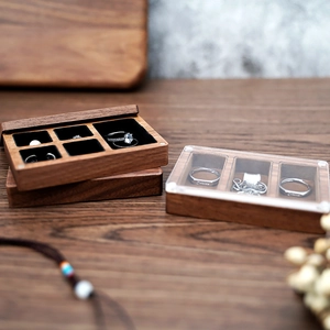 Detail of walnut wood jewelry box with multiple slots for rings, necklaces and earrings