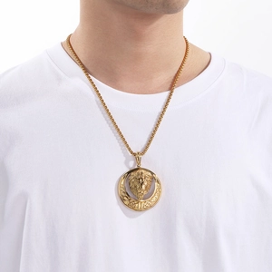 Close-up of golden lion head pendant with braided border on a stainless steel chain