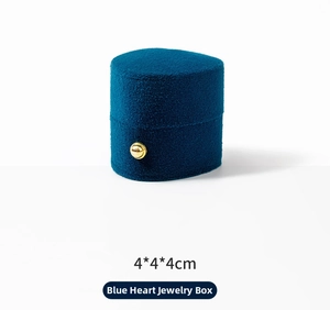 Close-up of deep blue velvet heart-shaped jewelry box with elegant gold bead decoration