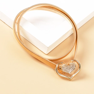 Detail einer goldenen Metall-Taillenkette mit herzförmiger Schließe und glitzernden Strass