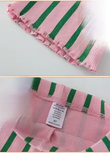 Close-up of pink and green ribbed knit girls' flare pants with elastic waist and ruffles