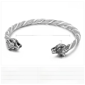 Detail of punk stainless steel wolf head cuff bracelet with twisted cable texture