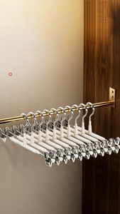 Detail showing the white rubber-coated non-slip bar and strong metal clips of the pants hanger