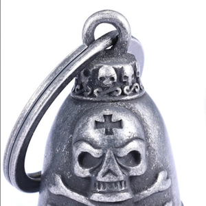 Macro shot of silver motorcycle bell pendant with skull and crossbones relief