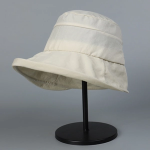 Detail showing the micro-wrinkle texture of the waterproof nylon sun hat in beige