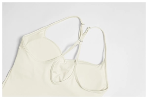 Détail du débardeur de yoga blanc cassé avec bretelles fines et encolure en U croisée au dos