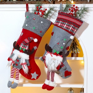 Detail of Christmas stockings with gnome dolls hanging on white festive archway
