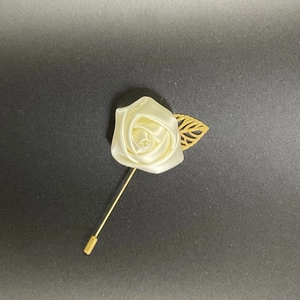Elegant men's suit lapel pin featuring a cream satin rose and a golden metal leaf