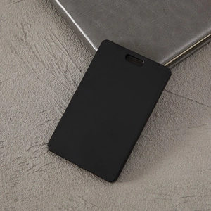 Close-up of a blank black ABS plastic ID card holder placed on a grey concrete background