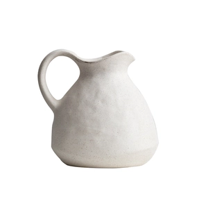 Matte white ceramic vase with handle and speckled texture on plain white background