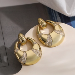 Detailed close-up of golden crescent earrings with inlaid clear zircon stones