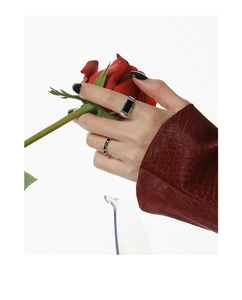 Artistic detail of S925 silver wide black enamel ring held against a red rose