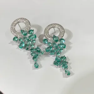 Détail de boucles d'oreilles en argent avec pompons en zircone verte en forme de poire