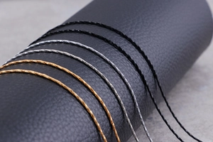 Macro shot of minimalist snake chain necklaces in gold, silver, and black on leather