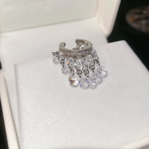 Vue macro détaillée d'un ear cuff argenté avec pampilles en zircon étincelant en boîte