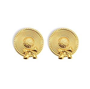 Macro detail of gold bow straw hat earrings showing intricate woven texture and beads