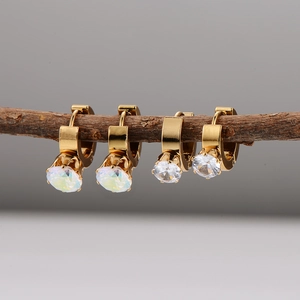 Minimalist gold hoop earrings with sparkling zircon gemstones on a natural branch