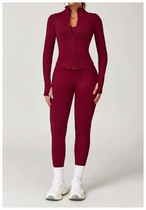 Detail of burgundy ribbed yoga set featuring a stand collar jacket and thumbhole sleeves